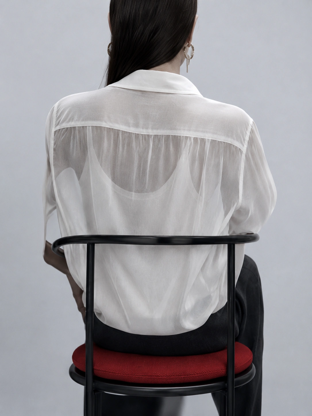 Subtle Senses study — translucent white shirt on black chair with red seat